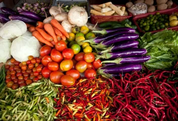 Vibrant selection of fresh vegetables arranged at an outdoor market stall.